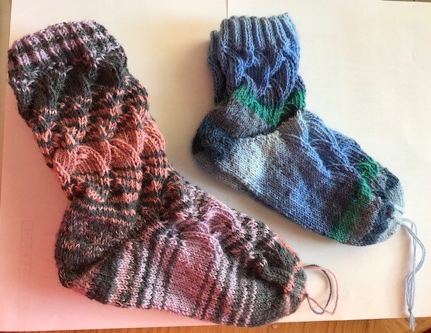 Zwei gestrickte Damensocken in Rosé-Grau und Blau-Grün mit Zopfmuster