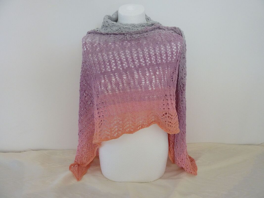 Gestricktes Dreieckstuch mit Farbverlauf (Grau–Lila–Rosa–Orange) und Lochmuster auf weißer Büste