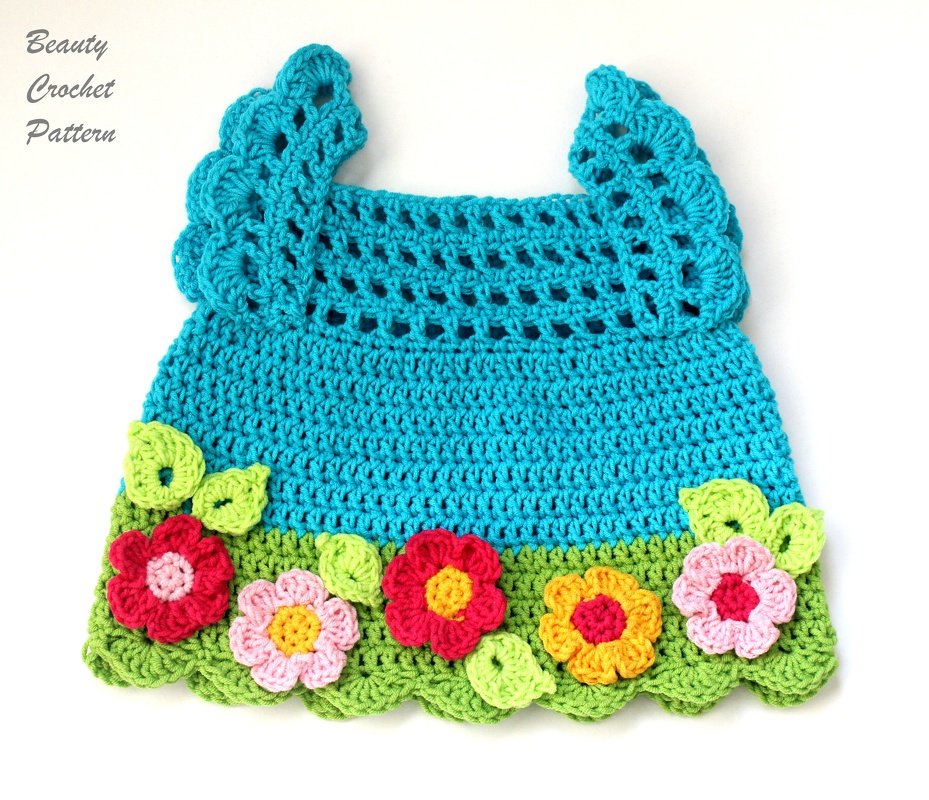 Türkis gehäkeltes Babyträgerkleid mit grüner Muschelbordüre und bunten Blumen