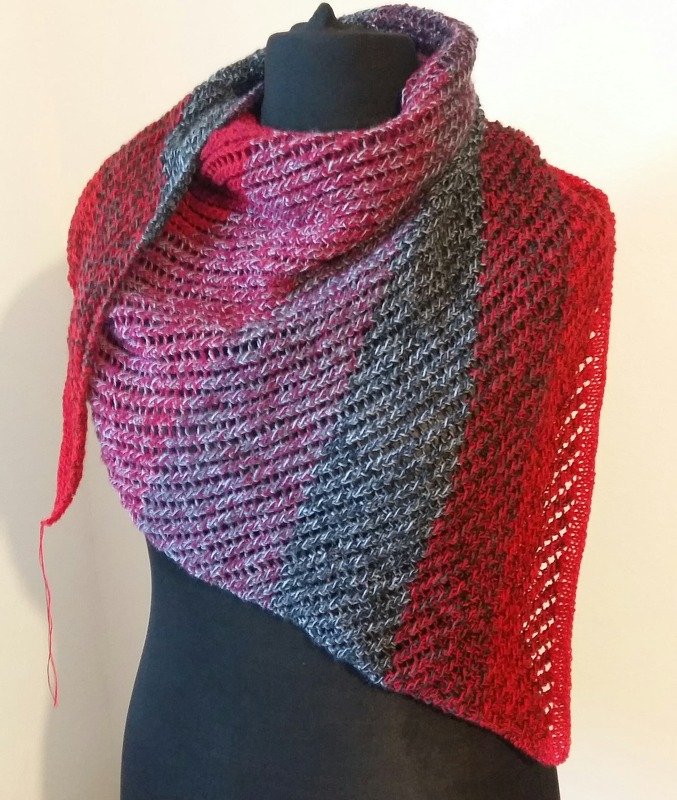 Dreieckiges handgestricktes Tuch in Rot, Fuchsia und Grau auf einer schwarzen Schneiderpuppe