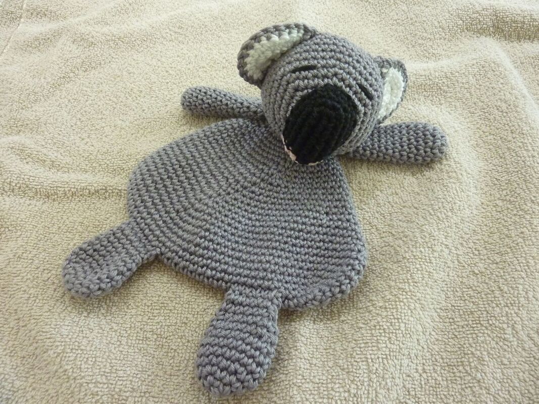 Gehäkeltes graues Koala-Schmusetuch auf hellem Handtuch