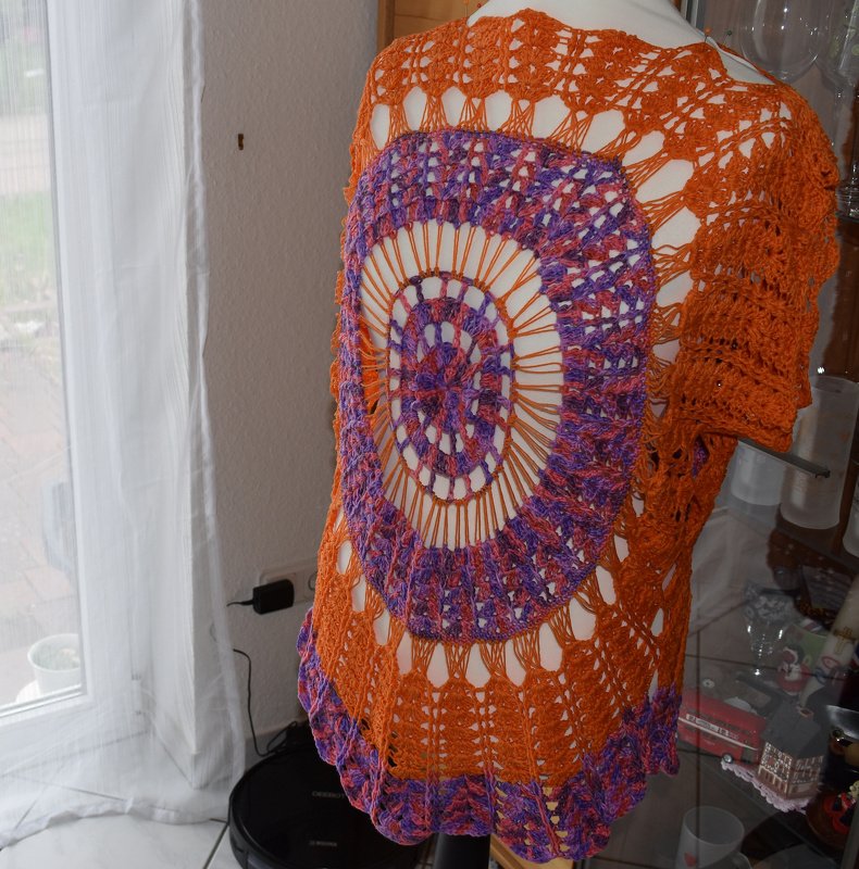 Häkelponcho Rückenansicht mit rundem orange-lila Motiv