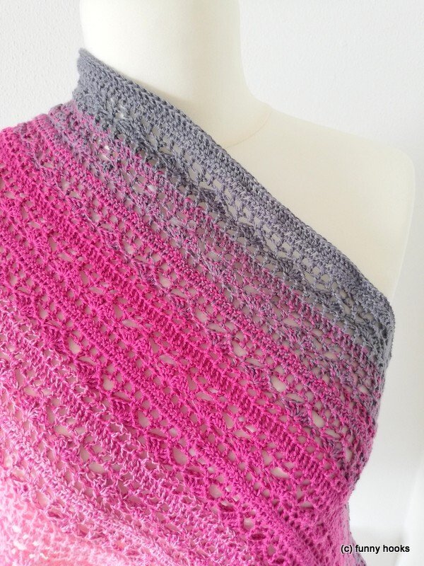 Lightweight crocheted ombre scarf in pink fading to grey on a white mannequin, showing lacy openwork and stitch detail.
