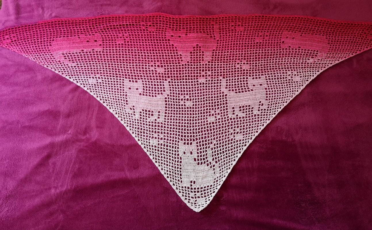 Dreieckiges weißes Filet-Dreieckstuch mit stilisierten Katzenmotiven auf magentafarbenem Stoff