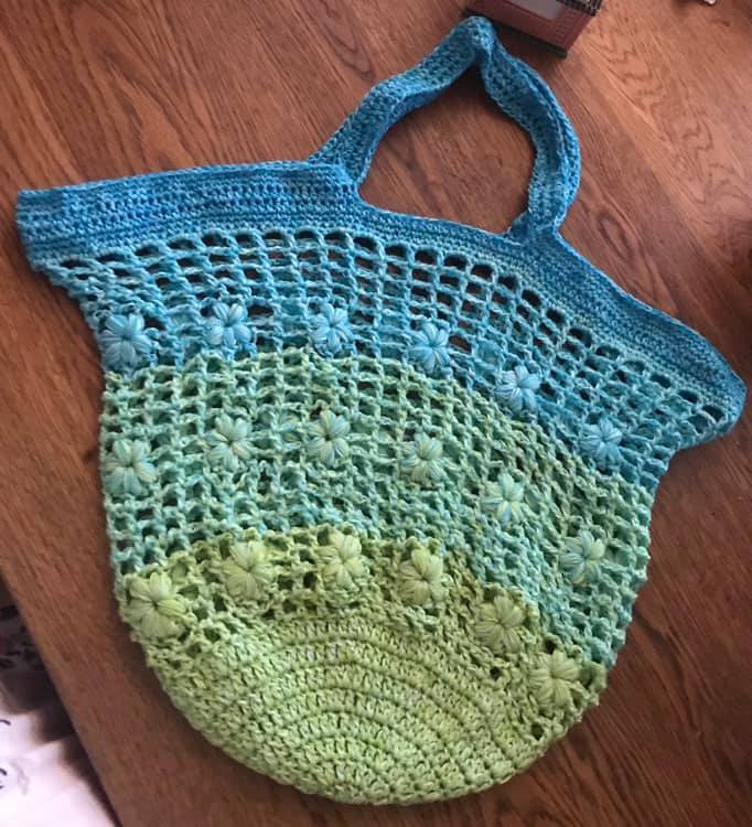 Gehäkelte Tasche in Türkis- und Grüntönen mit Blumenapplikationen