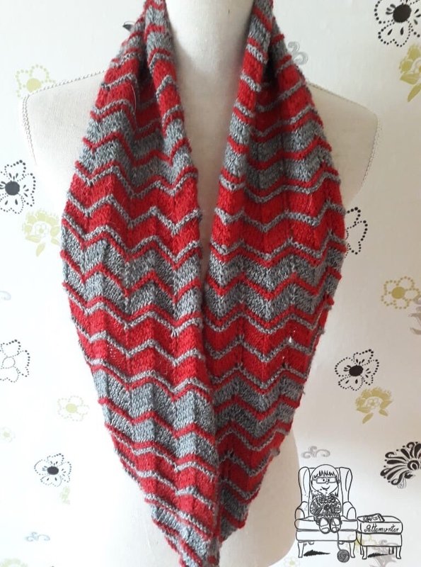 Gestrickter Loop-Schal in Rot und Grau mit Zickzackmuster an einer Schaufensterpuppe