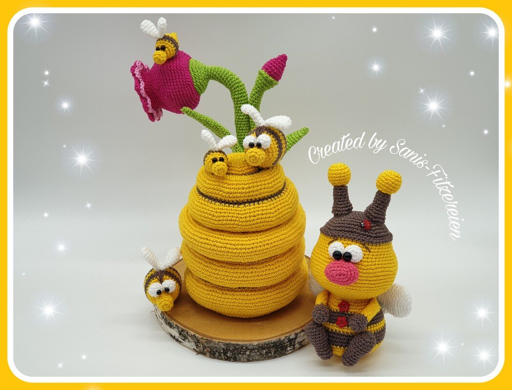 Gehäkelte Bienen-Amigurumi mit Wabenhaufen, Blüte und Holzscheibe