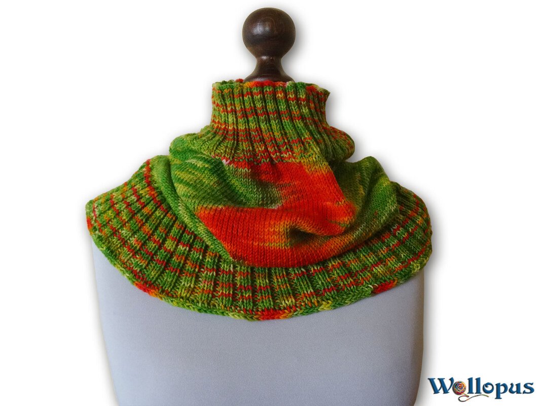 Gestrickter grün-orange Loop-Schal mit hohem Rippenkragen auf einer Schaufensterpuppe