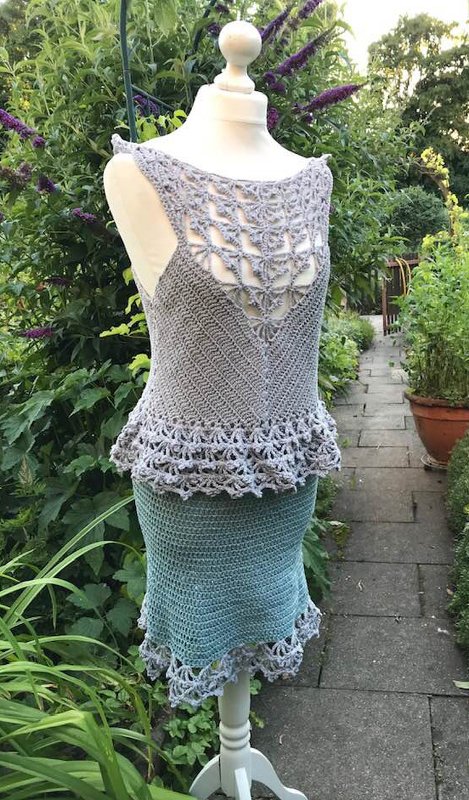 Mannequin mit zweiteiligem Häkelensemble: Oberteil mit Lochmuster, strukturierte Mittelzone und Rock mit Rüschensaum