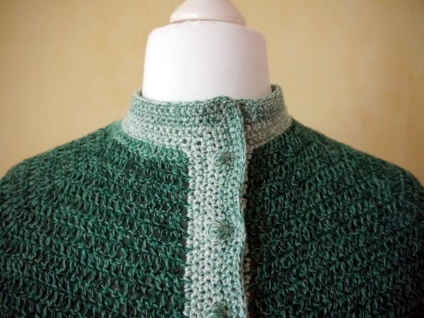 Grüne gehäkelte Damenjacke, Detail von Stehkragen und Knopfleiste