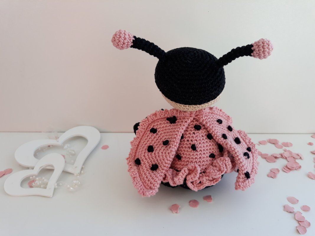 Detailansicht Rückseite eines gehäkelten Marienkäfer-Amigurumi mit Rüschenrock und schwarzen Punkten