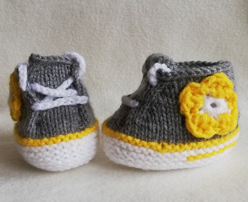 Paar gestrickter Babysneaker in Grau, Weiß und Gelb mit Schnürung