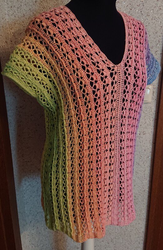 Gehäkelte Damen-Tunika mit V-Ausschnitt in Grün-, Rosa- und Blautönen auf schwarzem Mannequin