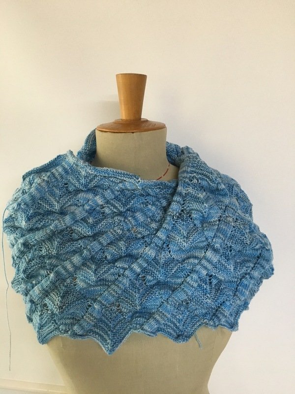 Hellblauer gestrickter Loop mit wellenförmigem Muster auf Schneiderbüste