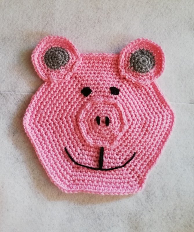 Gehäkelter rosa Topflappen in Form eines Schweins, sechseckig mit Ohren und Schnauze