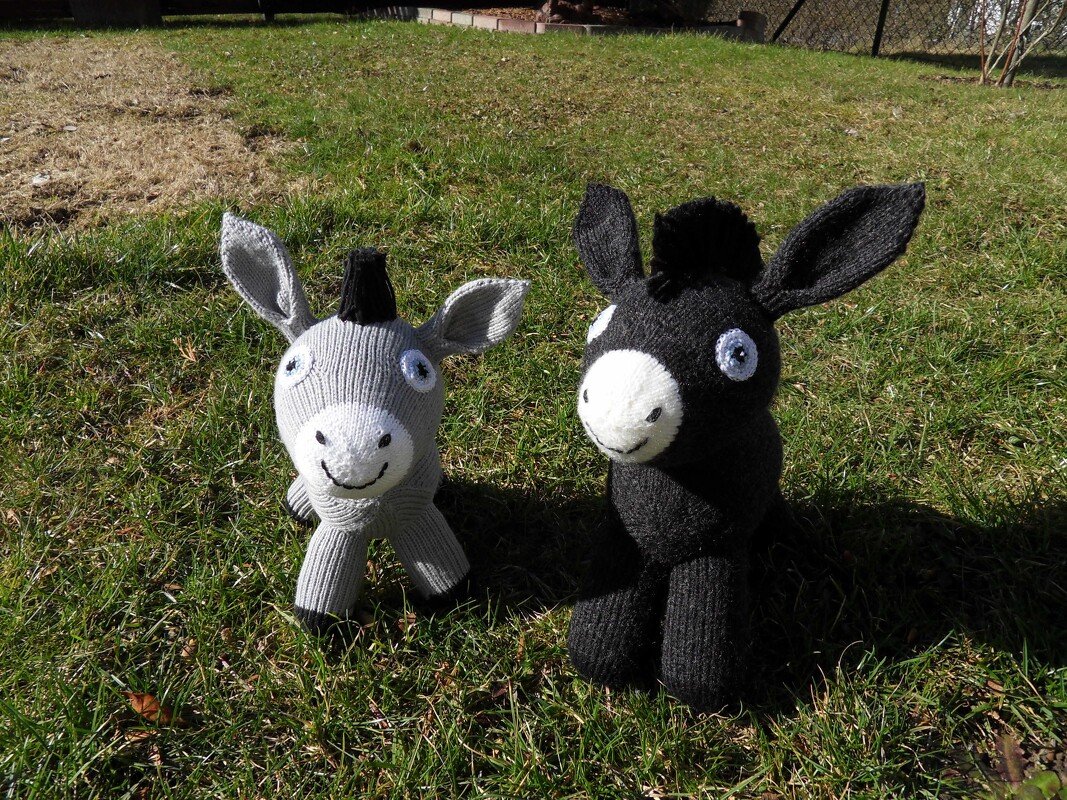 Nahaufnahme von zwei gestrickten Amigurumi-Eseln mit sichtbarer Maschenstruktur