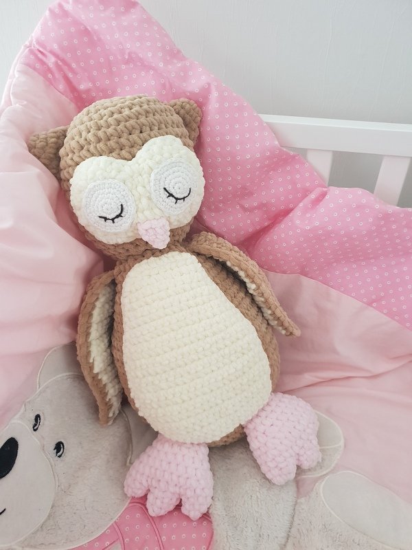 Nahaufnahme einer gehäkelten Eule mit applizierten Augenringen, Flügeln und dreiteiligen Füßen