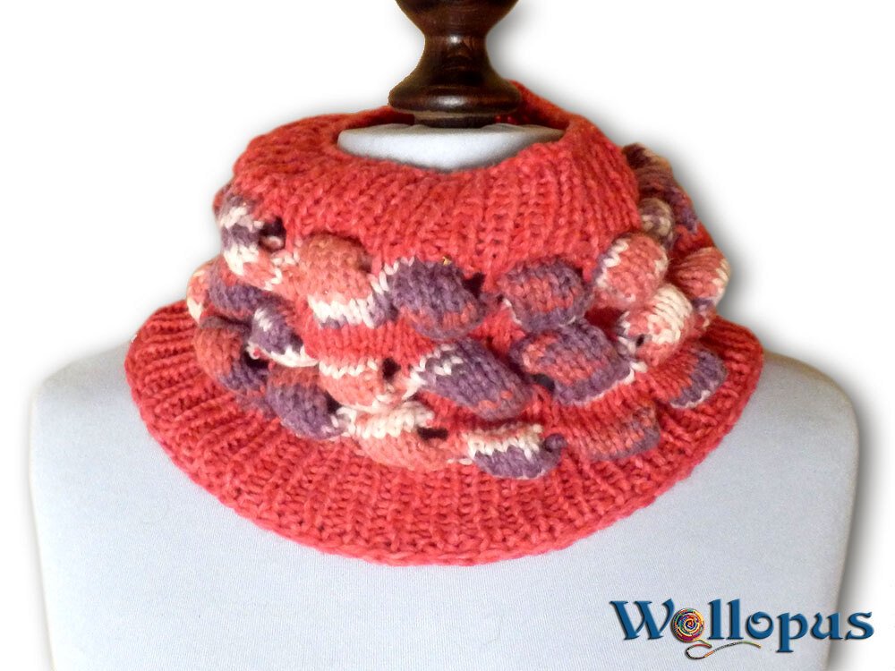 Korallfarbener gestrickter Loop mit violett-rosa Noppen auf Büste