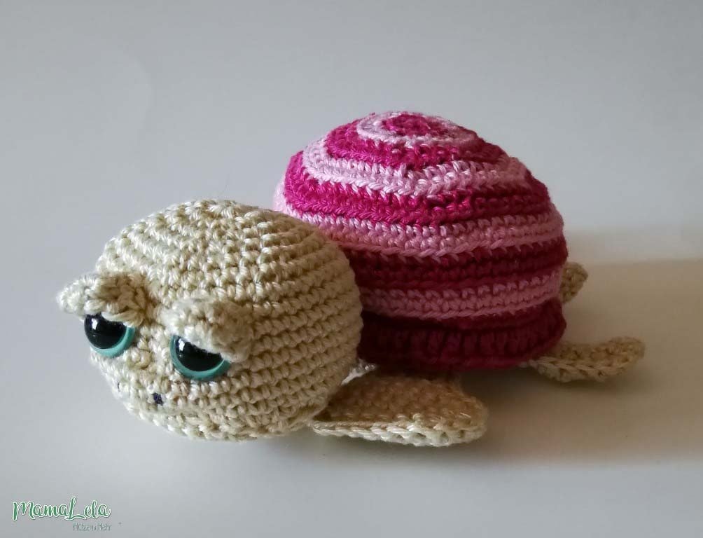 Amigurumi-Schildkröte gehäkelt mit beigem Kopf und rosa/dunkelrosa gestreiftem Panzer