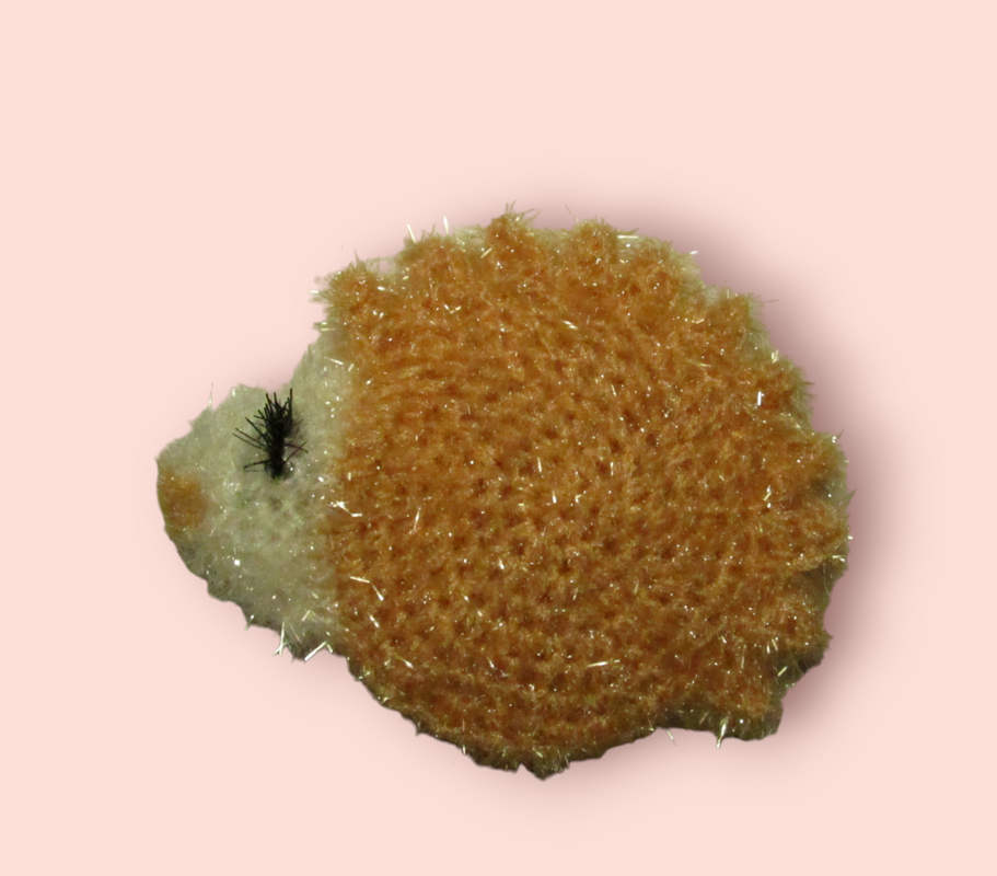 Gehäkelter Igel in Beige und Creme mit Glanzfasern auf rosafarbenem Hintergrund