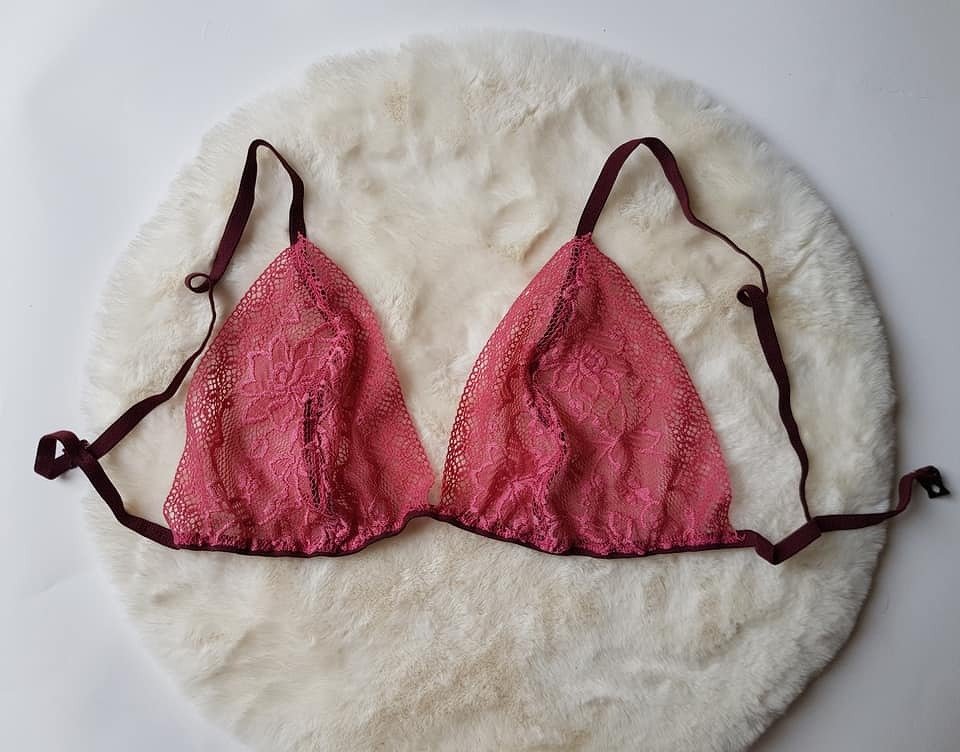 Rosa Spitzen-Bralette mit floralem Muster und dunklen verstellbaren Trägern auf hellem Kunstfell