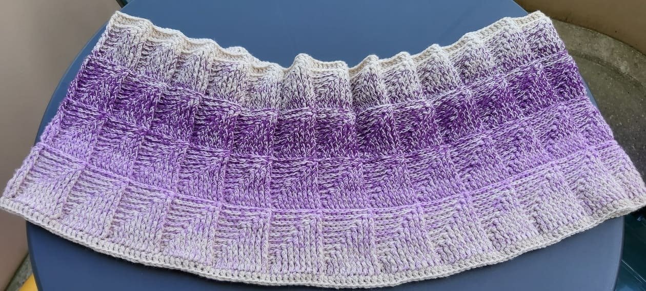 Gehäkelter Loop mit creme- bis lila Farbverlauf und Kästchenmuster