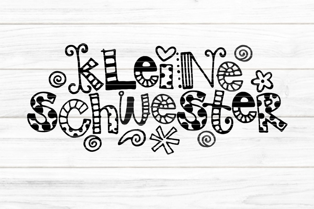 Schwarz-weißer, verspielter Schriftzug 'Kleine Schwester' mit Herzen und Ornamenten auf hellem Holzgrund