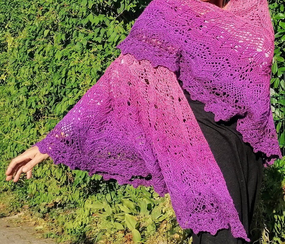 Halbrundes gehäkeltes Tuch mit Pink‑Lila Farbverlauf und Spitzenrand, über die Schulter gelegt