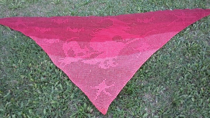 Dreieckiges gehäkeltes Tuch in Rot-Pink-Ombré mit Totenkopfmuster auf Gras