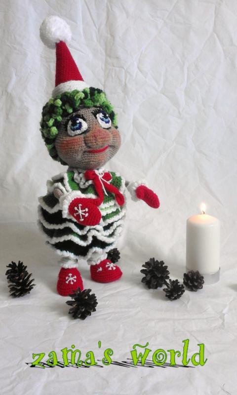 Gehäkelte Weihnachts-Amigurumi-Puppe mit roter Zipfelmütze, Rüschenrock und roten Stiefeln neben brennender Kerze