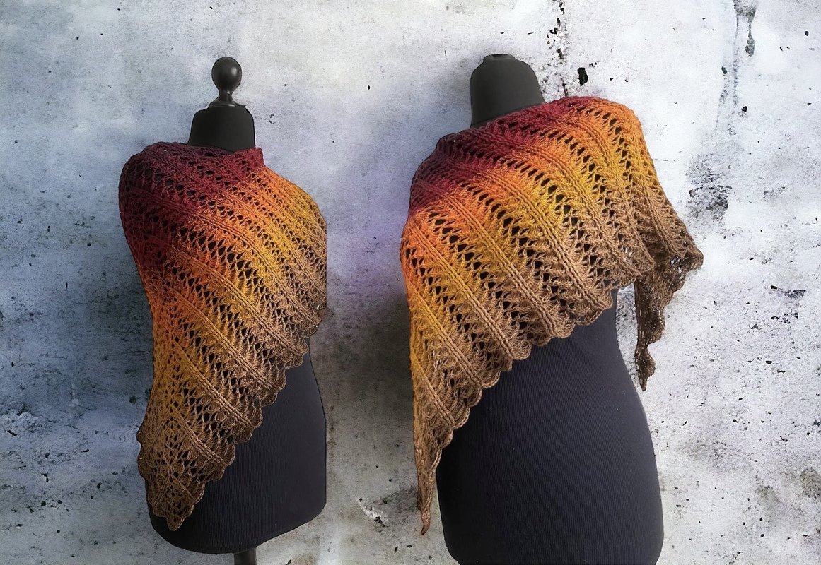 Two crocheted triangle shawls in red-to-brown ombre with lace openwork, shown on mannequins.