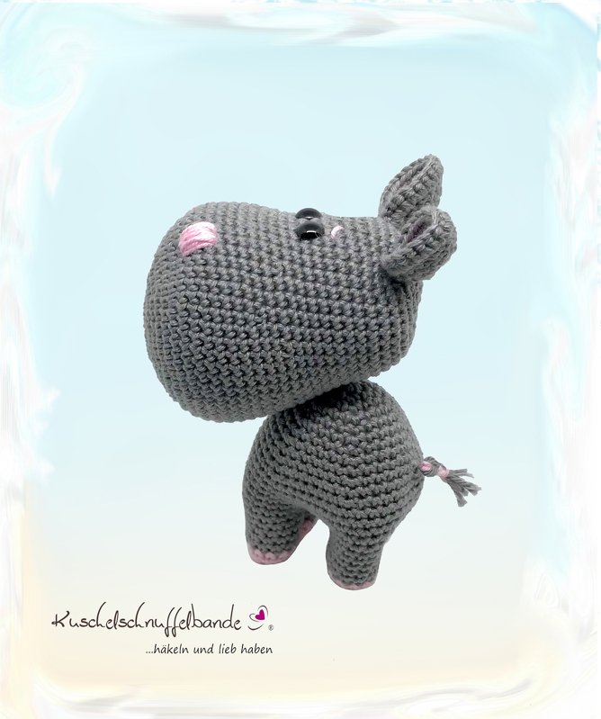Gehäkeltes graues Amigurumi-Nilpferd mit rosa Nase und schwarzen Augen, stehend