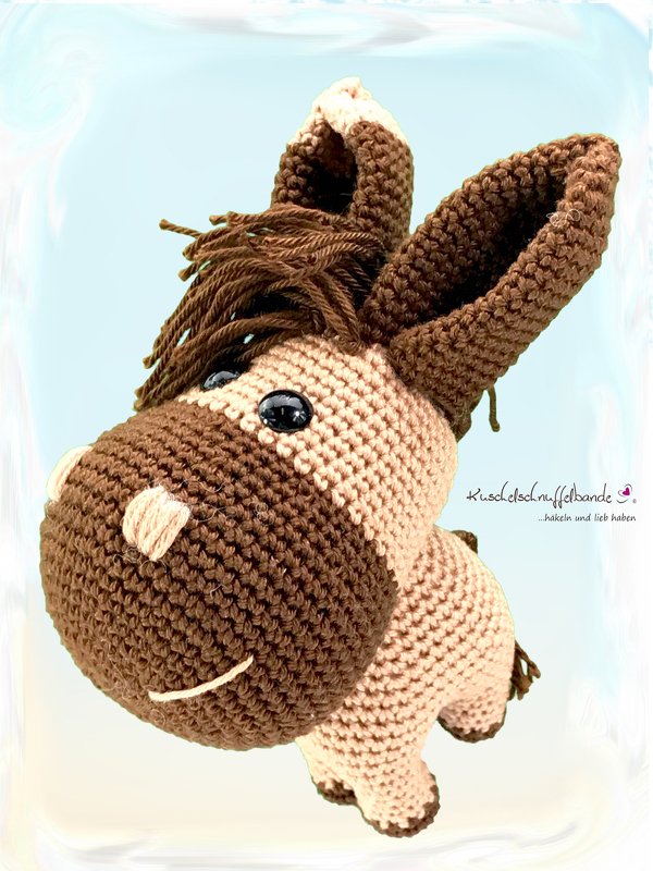 Nahaufnahme eines gehäkelten Esel-Amigurumis mit sichtbarer Maschenstruktur und Mähne