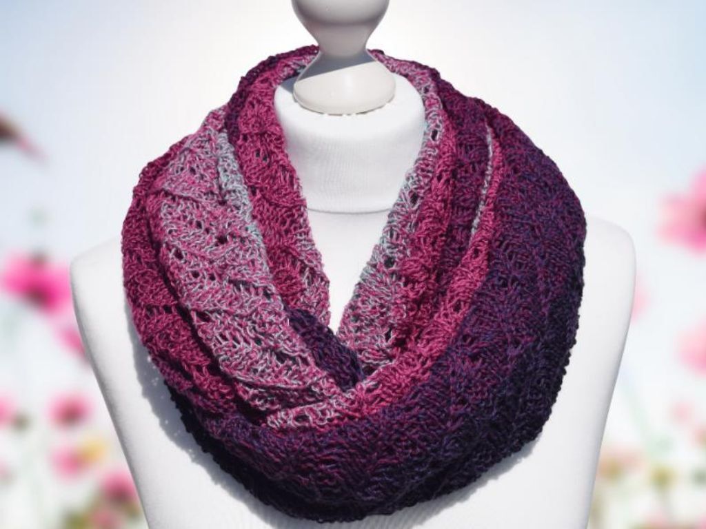 Gestrickter Loopschal mit Lochmuster und Farbverlauf von Rosa zu Purpur auf einer Schaufensterpuppe