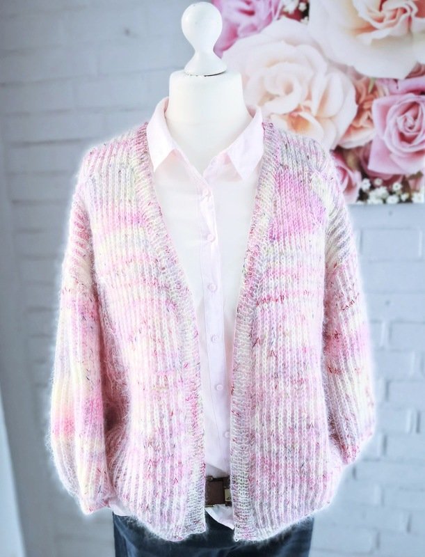 Kurz geschnittene offene Strickjacke in Pastellrosa auf Schaufensterpuppe mit Rippenstruktur