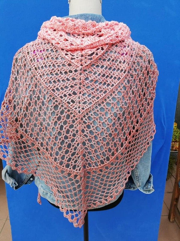 Rosa gehäkeltes Dreieckstuch mit offenem Lochmuster und Muschelkante, über einer Jeansjacke drapiert, Rückansicht.