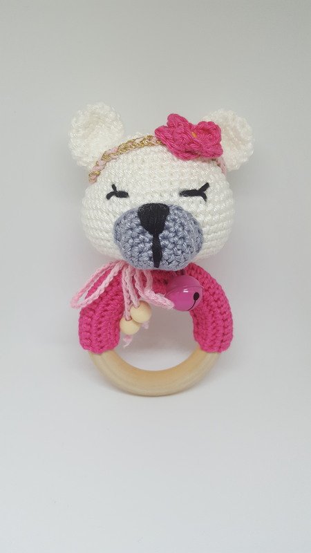 Rosa-weißer Häkelbär auf Holzring mit Perlen und kleinem Glöckchen