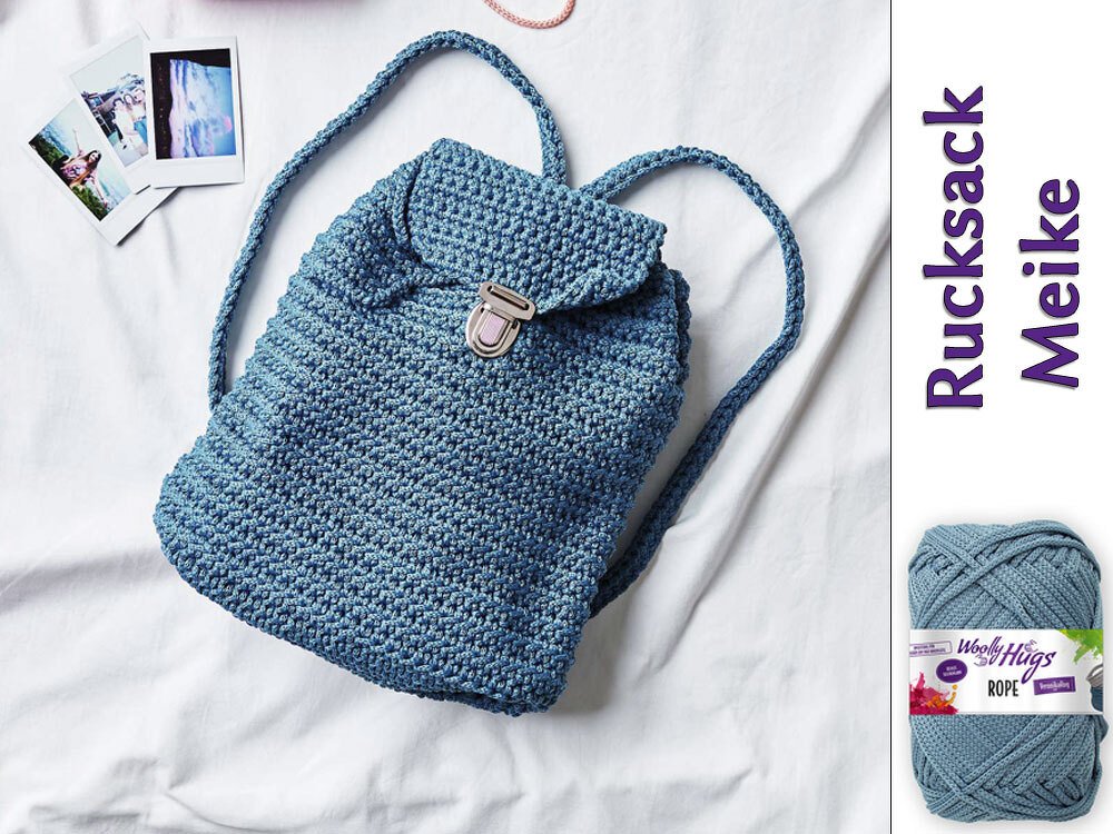 Jeansblauer gehäkelter Rucksack mit Deckelklappe und Metallverschluss auf hellem Hintergrund