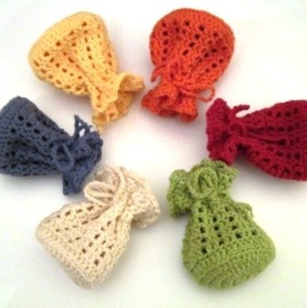 Sechs gehäkelte kleine Säckchen in Gelb, Orange, Rot, Grün, Blau und Natur mit Kordel