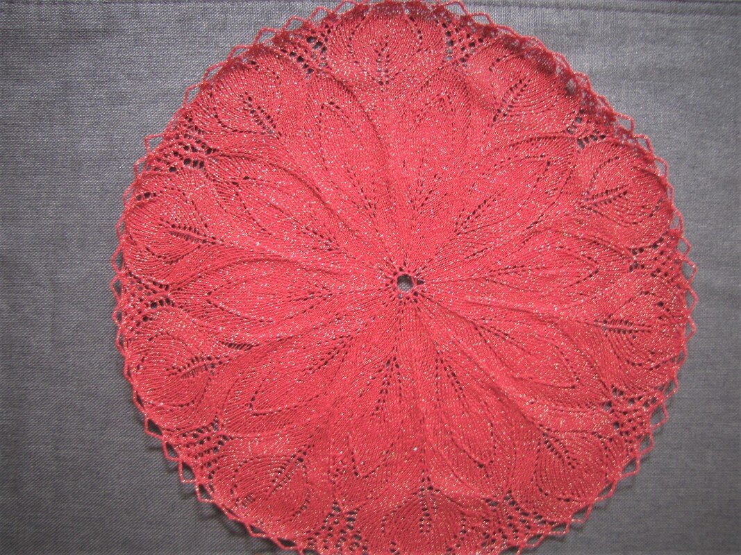 Rotes rundes Deckchen mit filigranem Blatt- und Spitzenmuster