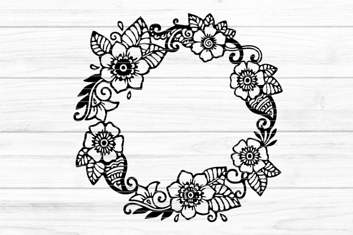Schwarzer floraler Blumenkranz als Silhouette auf hellem Holzgrund
