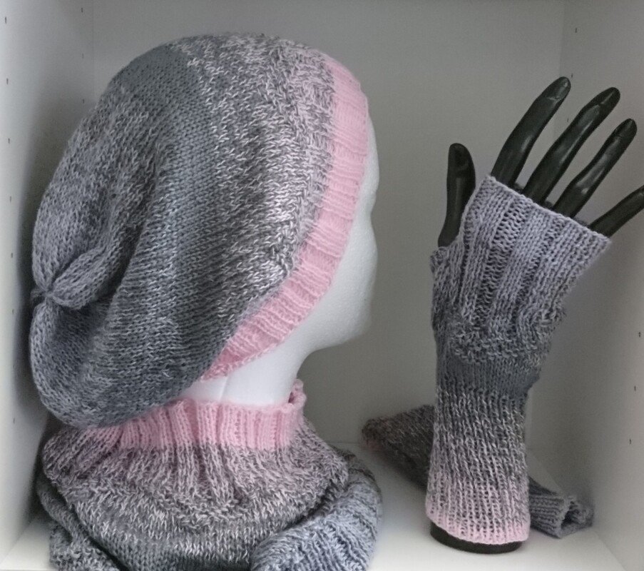 Grau-rosa gestrickte Mütze, passender Halswärmer und fingerlose Stulpen auf Schaufensterpuppe
