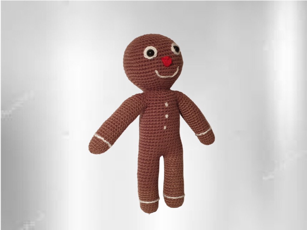 Gehäkelter brauner Lebkuchenmann Amigurumi mit weißen Zierlinien und roter Nase