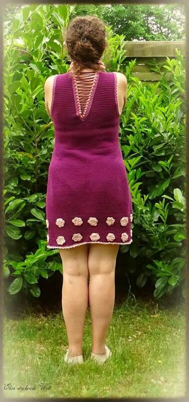 Gehäkeltes pflaumenfarbenes Kleid, Rückenansicht mit geschnürtem V
‑Ausschnitt und hellen Blütenapplikationen am Saum