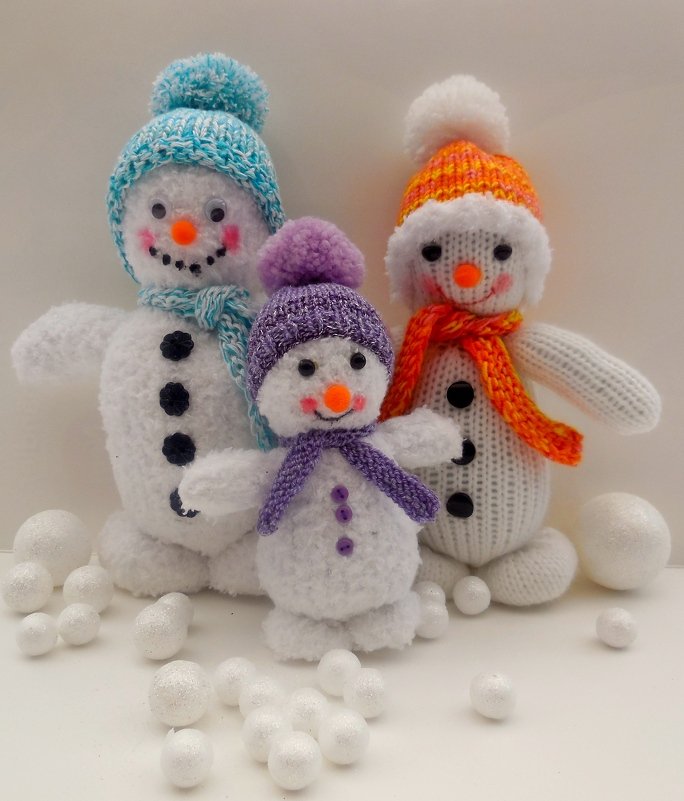 Gestrickte Schneemänner mit Details wie Bommelmützen, Schals und Knöpfen