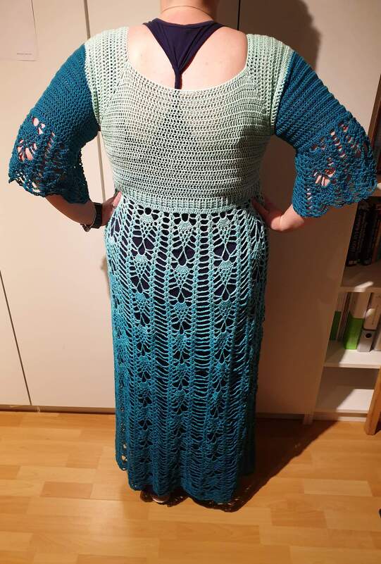 Rückansicht eines gehäkelten Tops und eines langen Rocks in Mint- und Türkistönen.