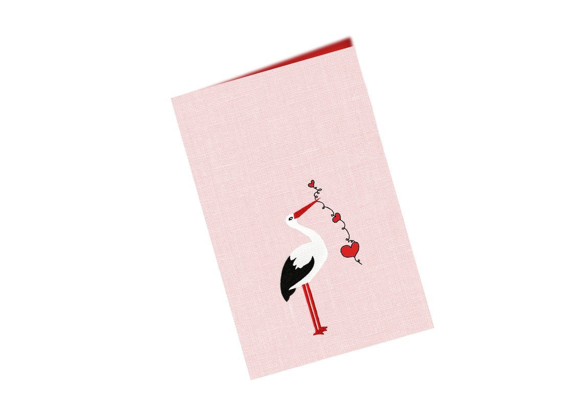Weißer Storch mit schwarzem Flügel und roten Herzgirlanden auf rosa Stoff, Stickmotiv