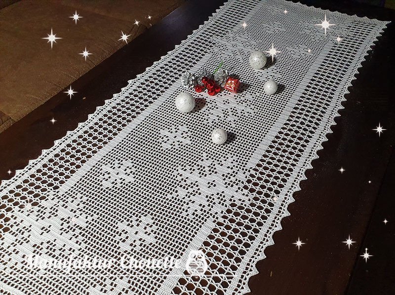 Weißer gehäkelter Filet-Tischläufer auf dunklem Holztisch mit weißen Weihnachtskugeln und kleinen roten Dekoakzenten