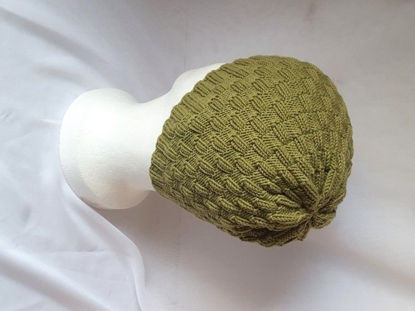 Olivgrüne gestrickte Beanie mit Strukturmuster auf weißem Kopfmodell