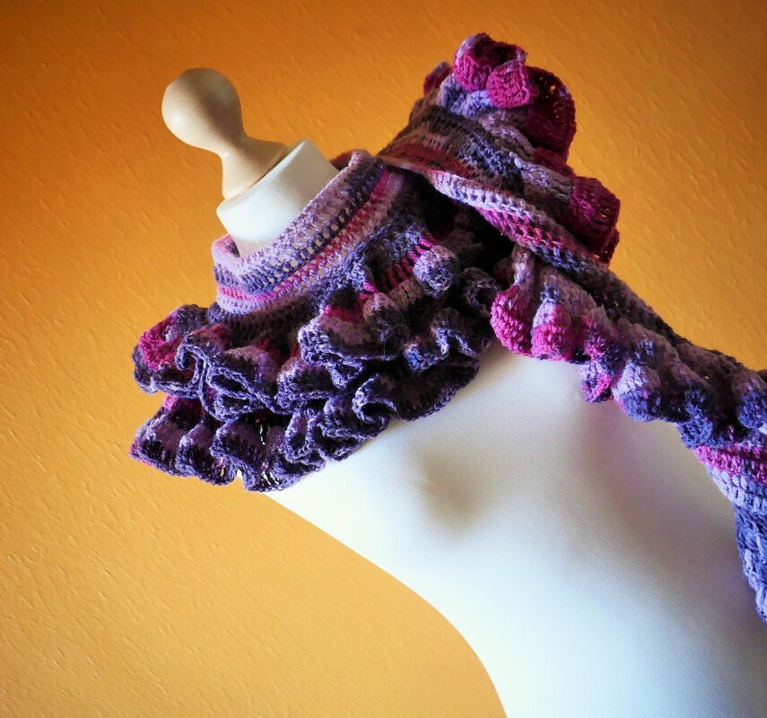 Gehäkelter Rüschen-Schal in Violett- und Pinktönen auf Schaufensterpuppe